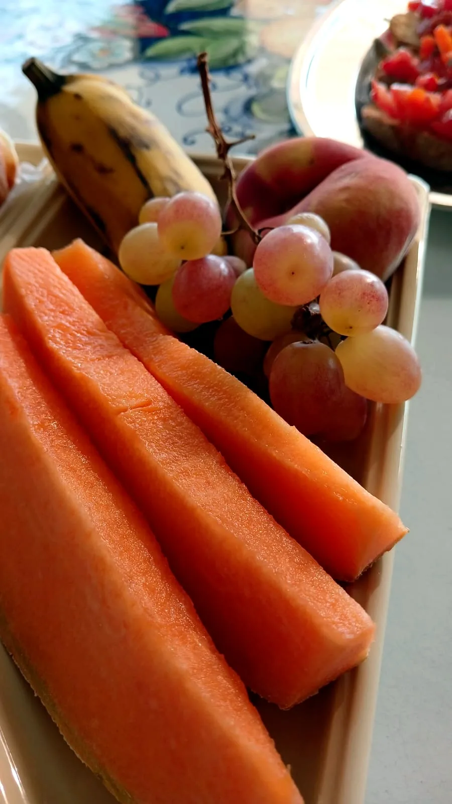 Melone, uva e pesche sulla tavola della colazione